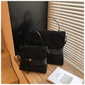 Detail view of large and small frosted black tote bags with metal buckles on wooden steps - Black Large