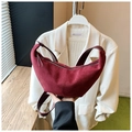 Detail of burgundy suede crescent bag showing premium matte texture and wide strap - Red