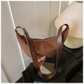 Detail of a dark brown suede hobo bag with sleek leather handle and silver hardware - Brown