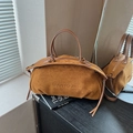 Brown suede Boston handbag with dual zippers and minimalist logo on a mirrored surface - Brown