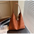 Detailed shot of large tan tote bag with unique diagonal stitching and wide shoulder strap - Brown