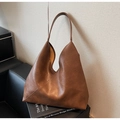 Detail of dark brown tote bag showing smooth PU leather texture and diagonal stitching - Caramel color