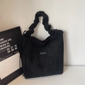 Detalle de bolso tote de ante negro con asa fruncida y práctico bolsillo frontal - Negro