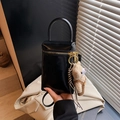 Mini bolso de mano en charol negro con cremallera dorada y un colgante de oso de peluche - Negro