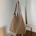 Gros plan du cabas en daim marron sur un cintre montrant la texture et le design - Camel