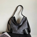 Detail van grijze luipaard canvas tas met zwarte leren hoeken en slanke riemen - Zwart