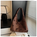 Close-up of laser-cut flower patterns on dark brown suede underarm tote bag - Brown