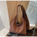 Detail of dark brown suede hobo bag placed by a round mirror in a cozy setting - Coffee