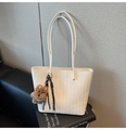 Dettaglio borsa tote intrecciata bianca con ciondolo a forma di cucciolo marrone - Beige