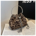 Detail der Leopard-Beuteltasche mit silbernem Ringgriff und Quastenzug auf einem Buch - Einheitsgröße / Khaki