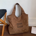 Brown faux suede tote bag with large capacity and logo detail on wooden floor - Brown