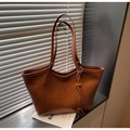 Detailansicht der karamellbraunen Shopper-Tasche mit feiner Lederstruktur und Quaste - Mit Anhänger / Braun