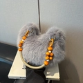 Détail d'un sac à main gris en fausse fourrure avec perles orange et boucle en métal - Gris