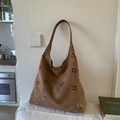 Primer plano del bolso tote de ante marrón con delicados motivos florales calados - Marrón