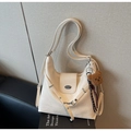 Detail of off-white leather hobo bag featuring vintage metal buckle and plush bear charm - Beige With Charm