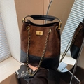 Bolso cubo de ante marrón y cuero negro con costuras acolchadas y cierre dorado - café