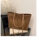 Sac fourre-tout caramel minimaliste disposé sur des accessoires pour un style artistique - Marron