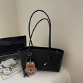 Minimalist black woven tote bag with V-shaped texture and a brown plush dog charm - Black