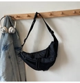 Dettaglio della borsa a mezzaluna in nylon nero con tracolla regolabile su un supporto - Nero Piccolo
