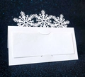 Primer plano de tarjetas de mesa blancas con copos de nieve cortados con láser en azul - Blanco