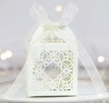 Nahaufnahme von weißem Laser-Cut Blumenmuster und Organza-Schleife auf Hochzeit-Geschenkbox - Elfenbein