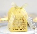 Nahaufnahme der gelben lasergeschnittenen Geschenkbox mit Herzmuster und Schleife - Gold