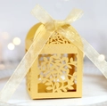 Detaillierte lasergeschnittene Blattmuster auf goldener Geschenkbox mit Seidenschleife - Gold
