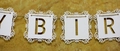 Dettaglio macro di striscione Happy Birthday bianco tagliato al laser con bordi pizzo - Bianco