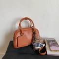 Retro brown leather Boston handbag with mini coin purse and teddy bear charm on grey surface - Caramel With Pendant