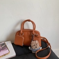 Detail of caramel leather bowling bag with mini coin purse and striped sweater bear charm - With Charm / Caramel color