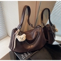 Detail of vintage dark brown faux leather tote with adjustable strap and metal chain - Coffee
