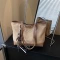 Khaki suede tote bag with brown leather trim and decorative bag charms on display - With Pendant / Khaki