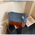 Details der Tasche aus Denim und braunem Leder mit Silberkette und Metallverschluss - Braun