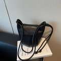 Minimalist black leather bucket shoulder bag with elegant thin straps and knot detail - Black