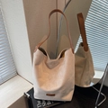 Cremefarbene Wildleder-Beuteltasche mit braunem Lederriemen in kreativer Spiegelung - Cremeweiß