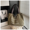 Primer plano de bolso tote de lona verde militar con asas de cuero marrón y bordado - Verde Militar