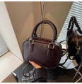 Vintage dark brown Boston bag with gold hardware and top handles in a stylish setting - Brown