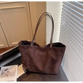 Macro detail of brown faux suede tote bag featuring a minimalist texture and sturdy strap - Brown