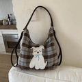 Detail van de geruite wollen draagtas met puppy patch en donkerbruine schouderriem - Bruin