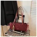 Détail du sac bandoulière en daim bordeaux avec lettrage doré et gland en perles - Rouge avec Pendentif