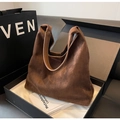 Detalle de un bolso hobo de ante marrón con asas de cuero en una caja de regalo de lujo - Marrón