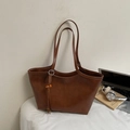 Grand sac cabas caramel avec pompon tressé et perles en bois sur un bureau blanc - Marron avec pendentif