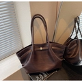Close-up of deep brown woven texture tote bag with metallic buckle and shoulder strap - Brown