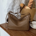 Sac fourre-tout en cuir marron avec logo embossé et bandoulière sur une table vintage - Marron