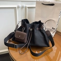 Détail du sac seau en toile noire avec fermeture à cordon et mini pochette en cuir brun - Noir