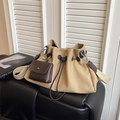 Détail du sac seau en toile kaki avec des accents en cuir marron et une large sangle - Khaki