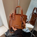 Braune Handtasche mit Webstruktur, Silberplakette und Perlenanhänger-Zubehör - Braun mit Anhänger