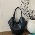 Detail of a large black leather tote bag with curved top and hanging coin purse - Black