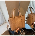 Detailed close-up of a brown woven bucket bag with dual handles and metal rings - Khaki