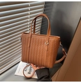 Detail of a brown woven leather tote bag with intricate texture and detachable strap - Brown
